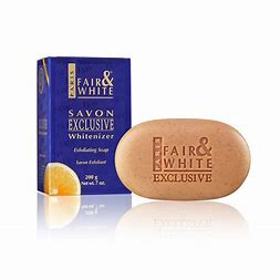 A bar of soap next to its blue packaging box, labeled 'FAIR & WHITE Exclusive Whitener' with a hint of a lemon graphic indicating the scent or flavor.