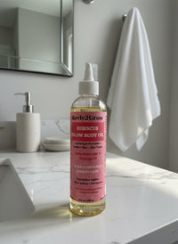 Thumbnail for Reviv2Grow hibiscus glow body oil bottle on a bathroom counter