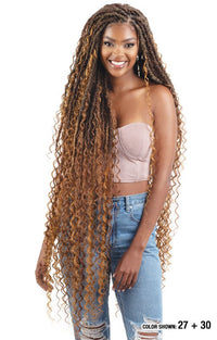 Thumbnail for Woman with long, curly hair styled in braids, wearing a strapless top and jeans.