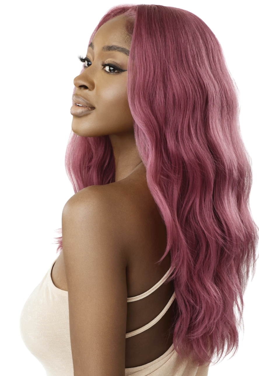 Woman with long, wavy, pink hair styled in a side part.