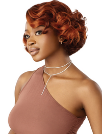 Thumbnail for Woman with styled red hair wearing a brown top on a white background