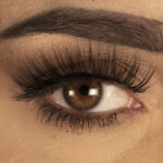 Close-up of a woman's eye wearing voluminous, long, brown false eyelashes