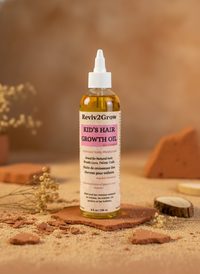 Thumbnail for Reviv2Grow Kids' Hair Growth Oil bottle on a wooden surface with a blurred natural background