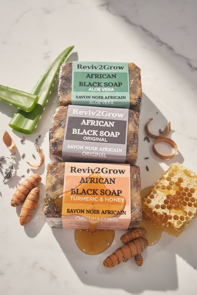 Three bars of African Black Soap from Reviv2Grow on a light background with honeycomb and turmeric.