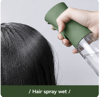 Thumbnail for Person using a green hair spray bottle on wet hair with a plain background