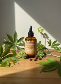Thumbnail for Reviv2Grow Castor Oil bottle on a wooden surface with plants around