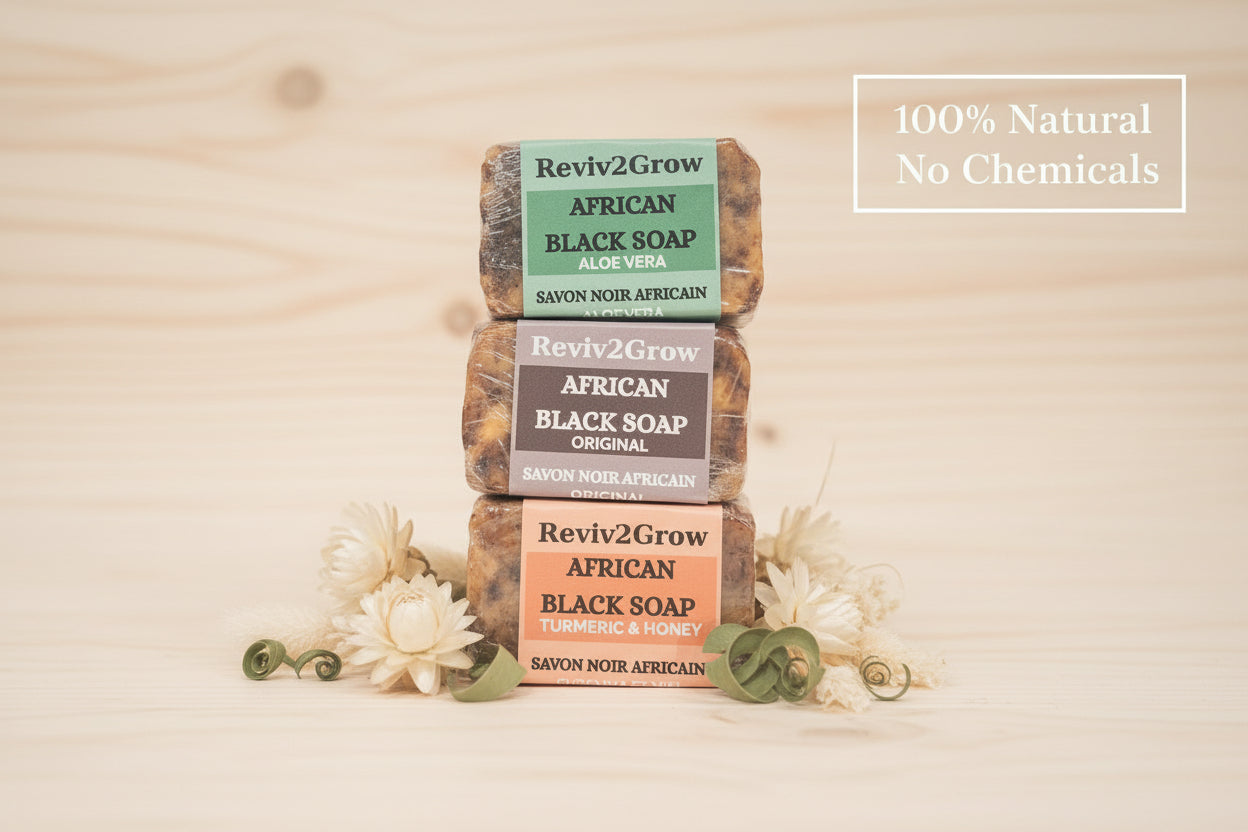 Stack of Reviv2Grow African Black Soap bars with packaging on a wooden surface.
