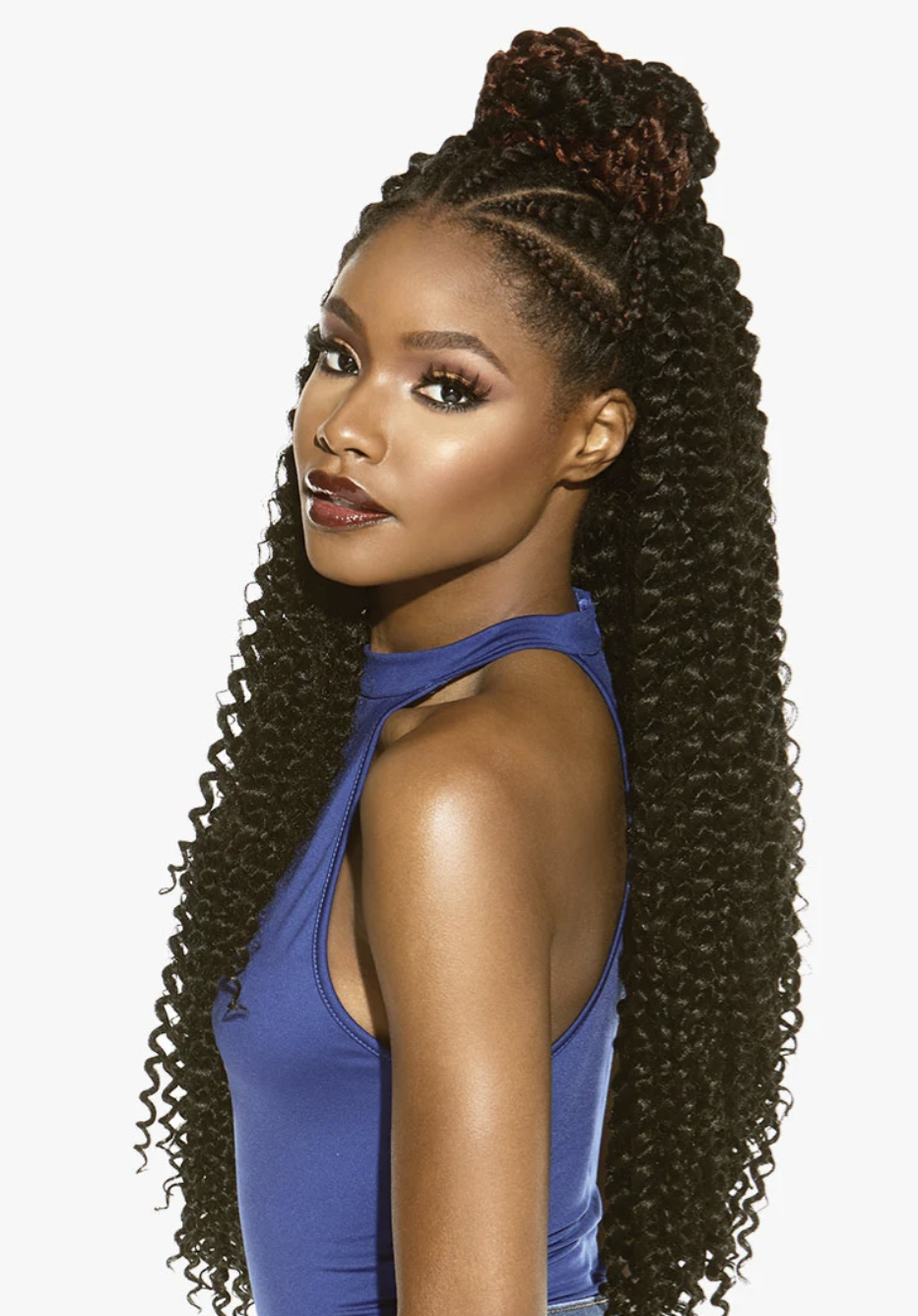 Woman with long, styled hair wearing a blue top on a white background