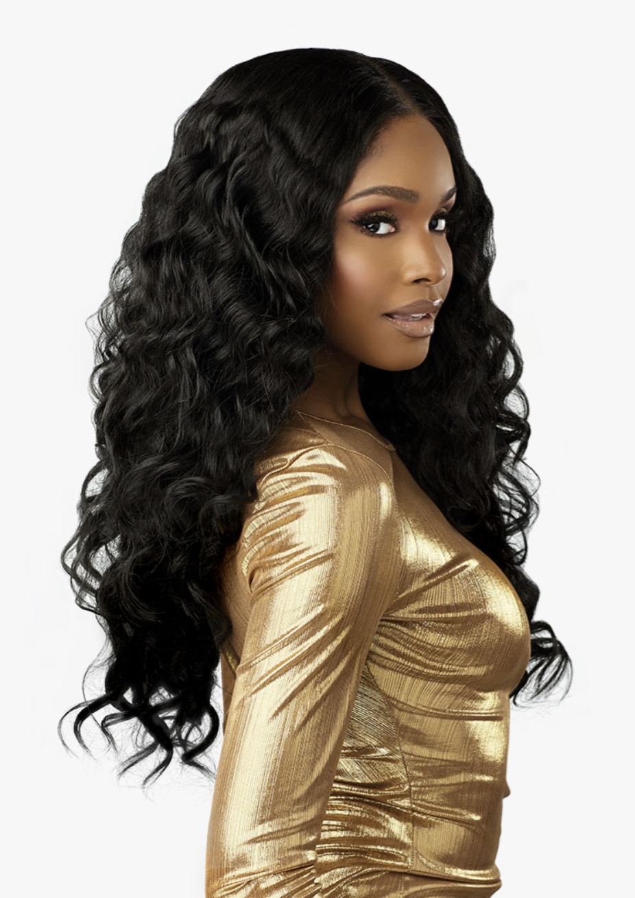 Woman with long, wavy black hair wearing a gold top on a white background