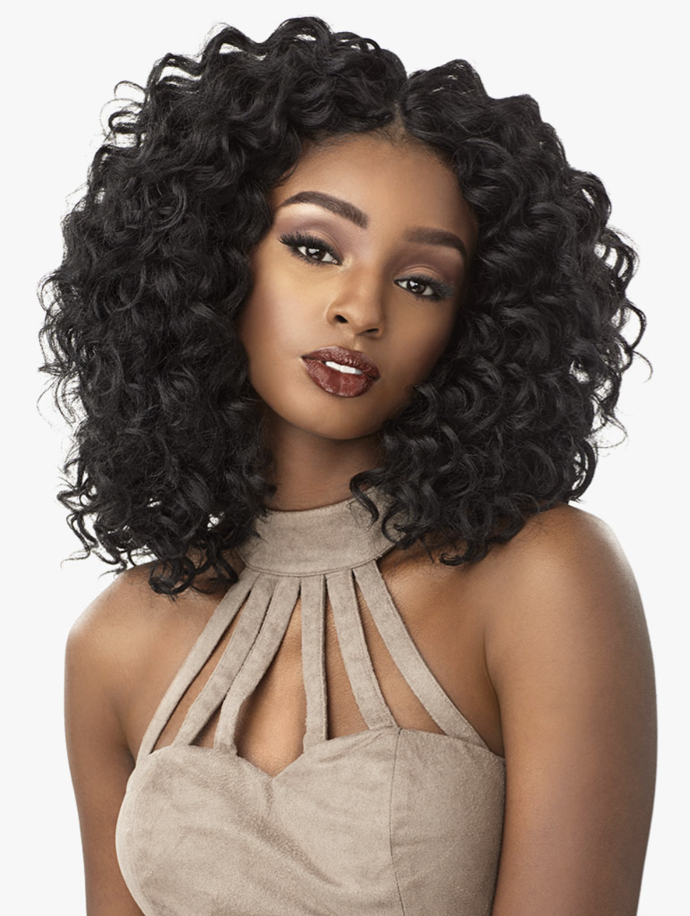 Woman with voluminous curly black hair wearing a beige halter top on a white background