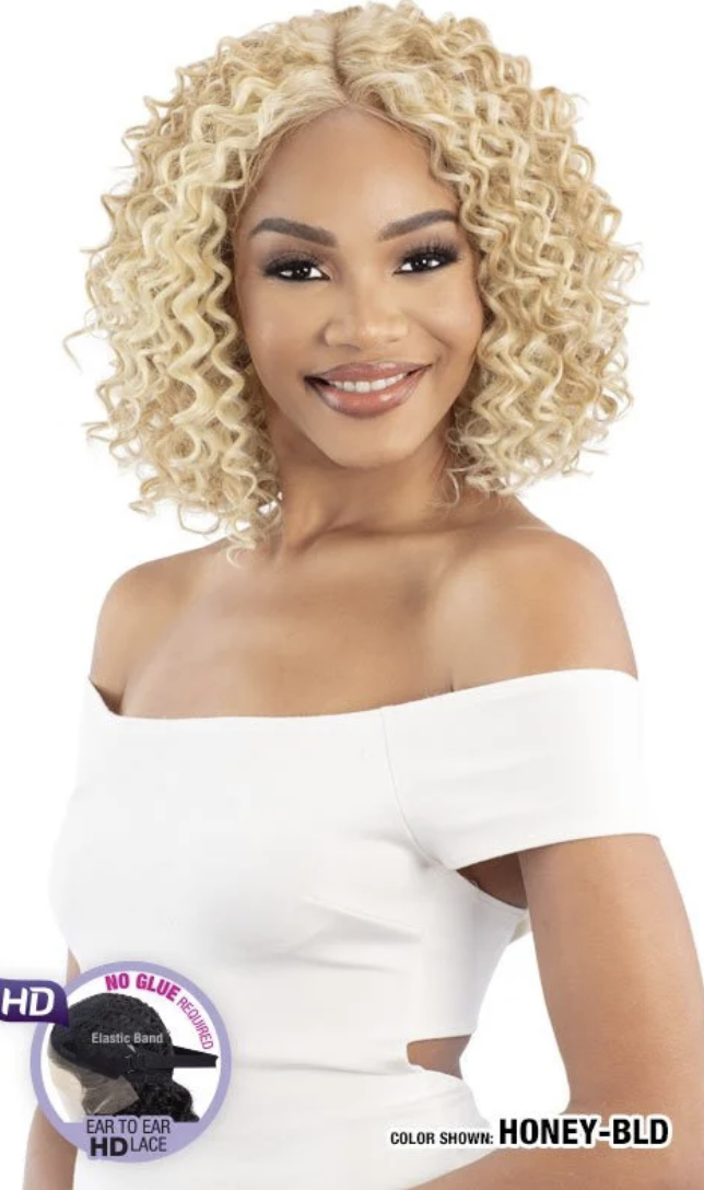 Woman with blonde curly wig wearing a white off-shoulder top, with a brand logo in the corner.
