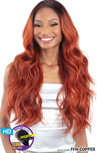 Woman with long, wavy, copper-colored hair wearing a white top.