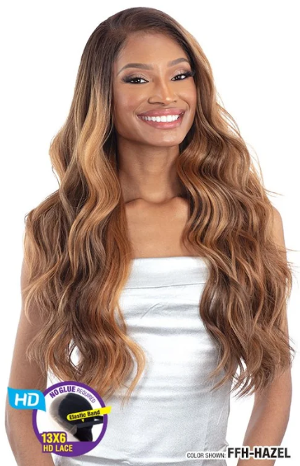 Woman with long, wavy hair styled in a white top, with a product label on the side.
