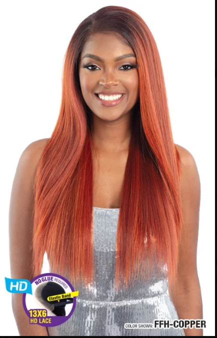 Woman with long, straight, copper-colored hair wearing a silver top on a white background.