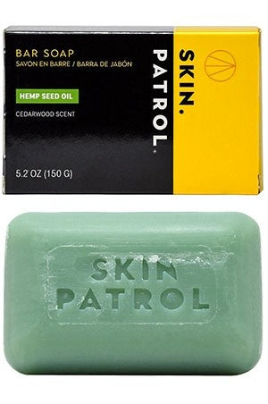 A bar of soap with 'SKIN PATROL' engraved on it, accompanied by its packaging box which is yellow and black with text.