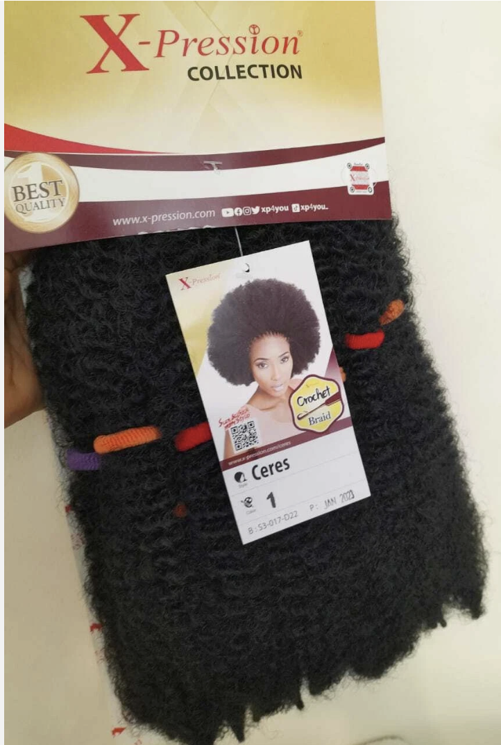 A packaged bundle of black curly hair extensions from X-Pression Collection, with a branded header card and a hanging product tag showing a model photo and the name Ceres.